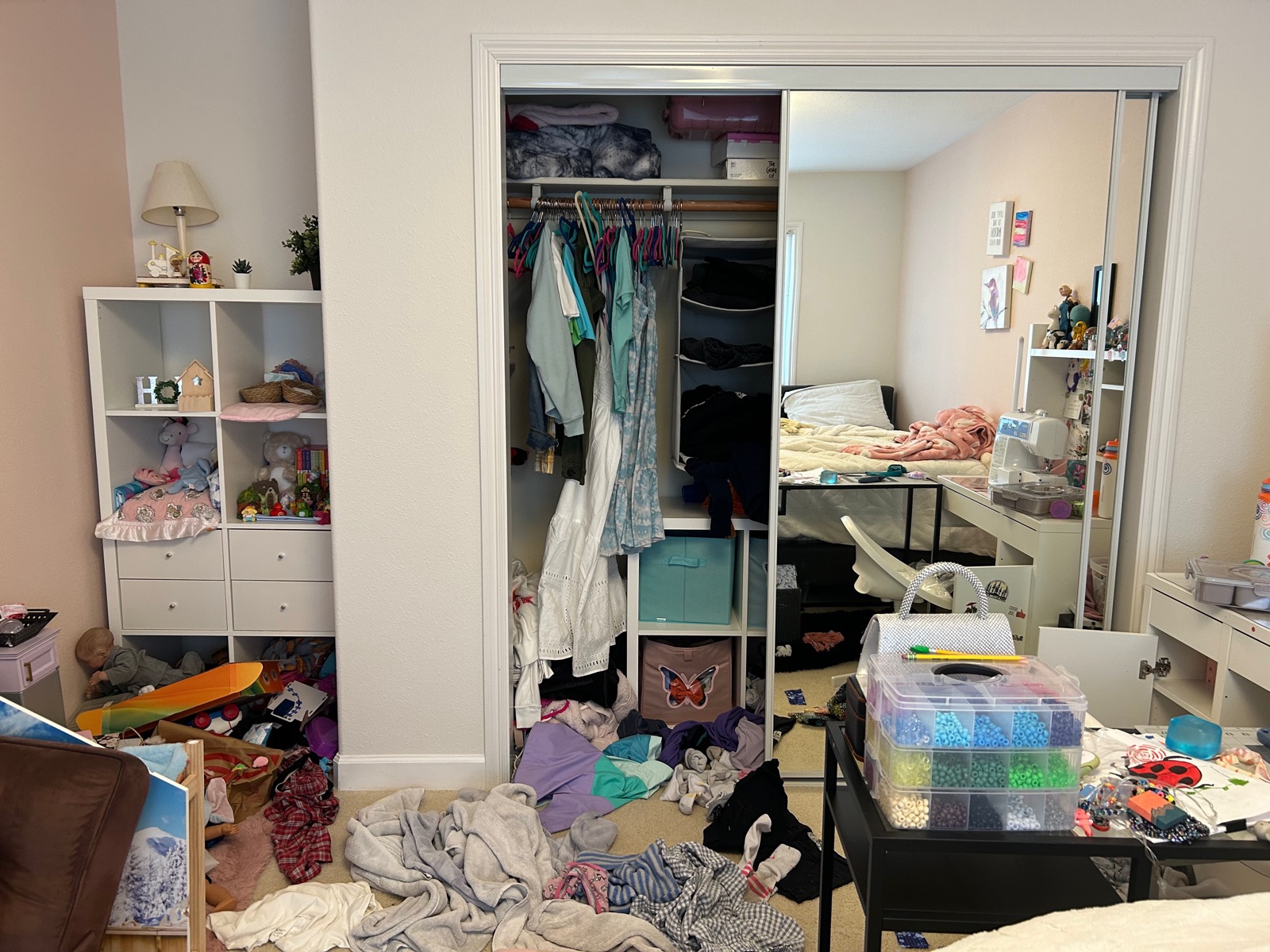 Closet before organizing — clothes half-hung, items piled on the floor