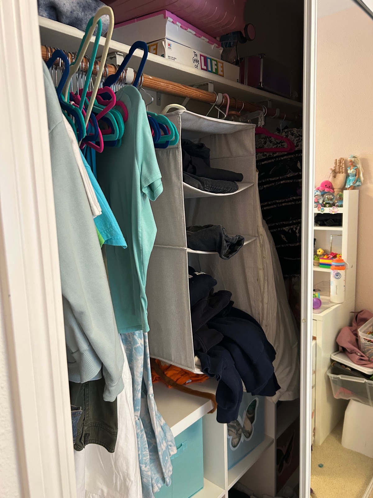 Closet shelving before organizing — cluttered hanging storage